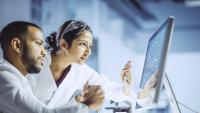 two researchers looking at computer screen